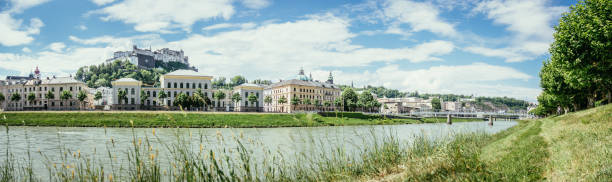 Salzburg summer time: Panoramic city landscape with Salzach with green grass and historic district stock photo