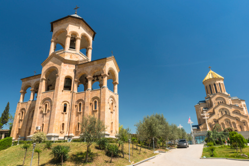 Holy Trinity cathedral in Tbilisi, main cathedral  of Georgia, built from 1995 to 2004, stands on a hill, looking down on the city, capital of Georgia. In front view bell tower on the left of the main church. Grass around.