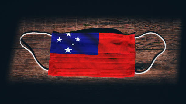 Samoa National Flag at medical, surgical, protection mask on black wooden background. Coronavirus Covid"u201319, Prevent infection, illness or flu. State of Emergency, Lockdown... Samoa National Flag at medical, surgical, protection mask on black wooden background. Coronavirus Covid"u201319, Prevent infection, illness or flu. State of Emergency, Lockdown... apia samoa stock pictures, royalty-free photos & images