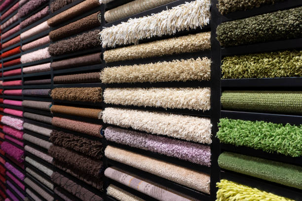 Samples of carpets of different colors on a stand in a store or production. Multi-colored carpet samples on the floor stock photo