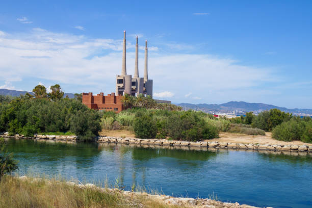 San Adrian, Fecsa Central Termica thermal power station in Badalona, Barcelona, Spain. Abandoned boiler room with three chimneys surrounded by nature and Besos stock photo