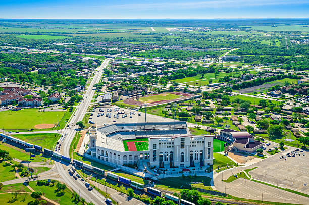 San Marcos Texas Aerial Panoramic Skyline, TXST Bobcat Stadium Aerial shot of San Marcos with residential homes, storefronts, and the Texas State University campus. universities in texas stock pictures, royalty-free photos & images