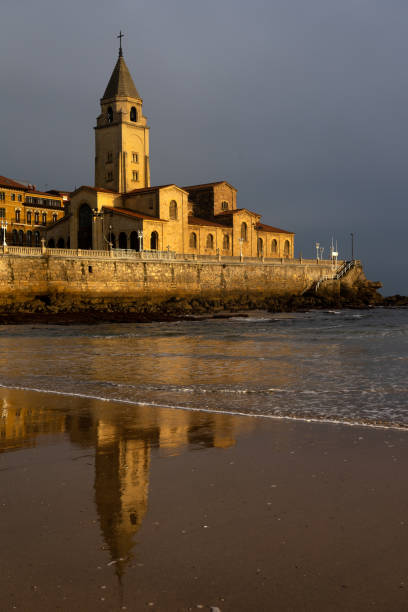 san pedro church in the san lorenzo beach illuminated by sun at sunrise in the city of gijon, asturias, spain - luis lorenzo 個照片及圖片檔