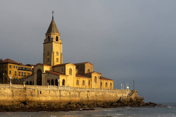 san pedro church in the san lorenzo beach illuminated by sun at sunrise in the city of gijon, asturias, spain - luis lorenzo 個照片及圖片檔