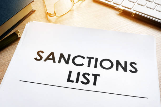 de lijst van sancties op een bureau. de akte van de overheid gesanctioneerde landen. - russia usa ukraine stockfoto's en -beelden