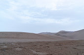 Sand mountain range in desert under blue sky