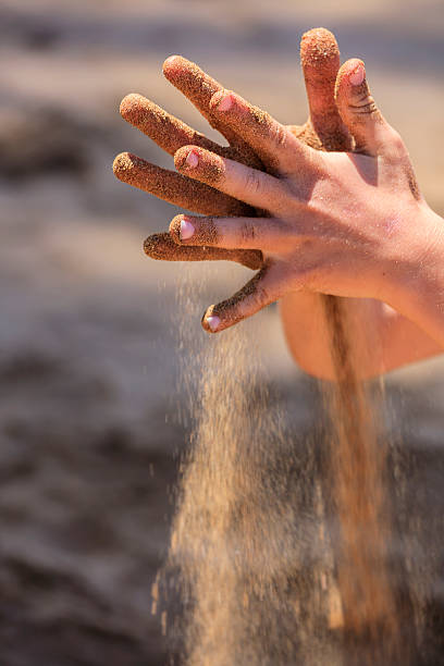 Sand through a child's hands stock photo