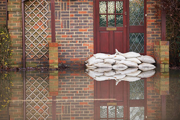 Sandbags near house door during flood Coping with extreme weather conditions flood photos stock pictures, royalty-free photos & images