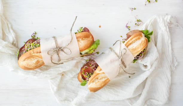 sandwiches met rundvlees, verse groenten en kruiden over witte houten achtergrond - plankje plant touw stockfoto's en -beelden