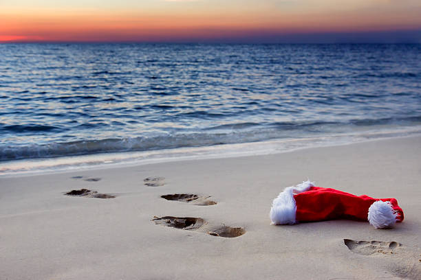 Santa Claus hat on beach at sunset stock photo