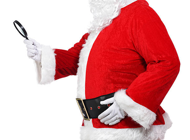 Santa Claus holding a magnifying glass stock photo