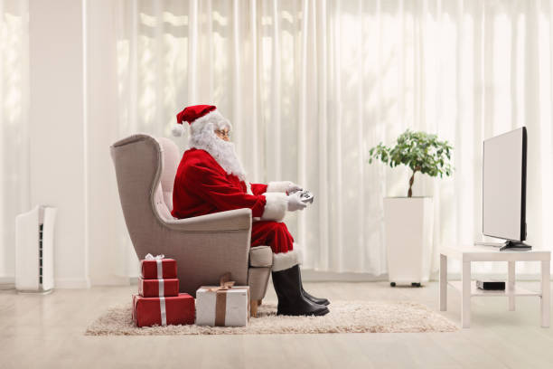 Santa claus with a joystick playing video games stock photo