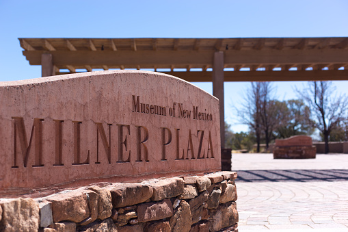 Santa Fe, NM: A sign on Santa Fe’s Museum Hill reading “Milner Plaza,” a large open plaza surrounded by various museums, indulging the International Folk Art Museum.