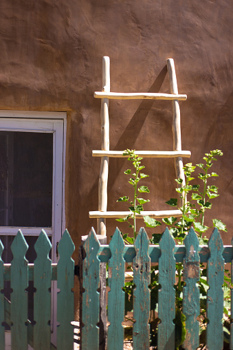 Santa Fe Style: Kiva Ladder Against Adobe Wall, Picket Fence