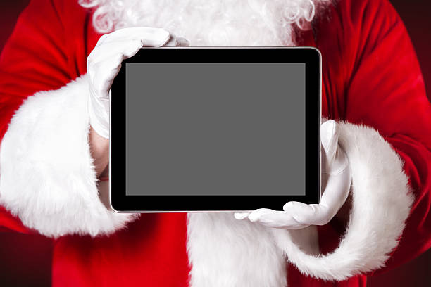 Santa holding a tablet with blank space stock photo