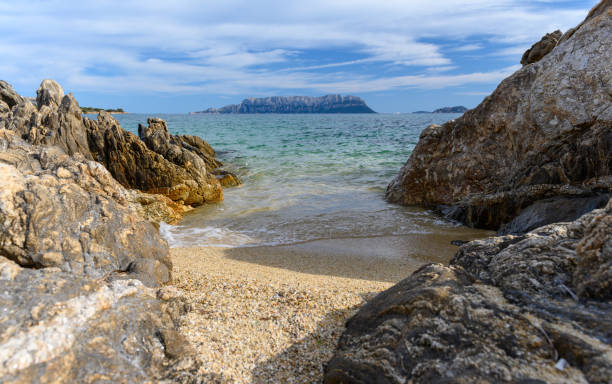 Sardinia rocky coast with sea view and island isola tavolara stock photo