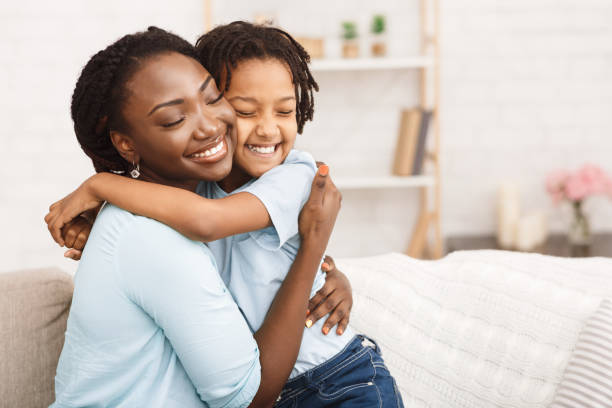 Satisfied black family feeling happy and joyful Lovely Family. African mother embracing her daughter, feeling happy and carefree. Copy space african american children stock pictures, royalty-free photos & images