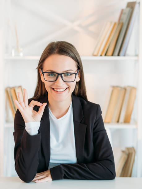 satisfied business woman okay sign approving deal stock photo