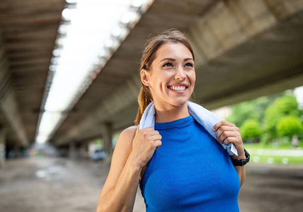 Satisfied girl holding towel after exercise stock photo