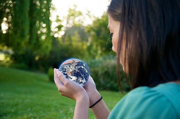 A young woman holding a globe, saving environment