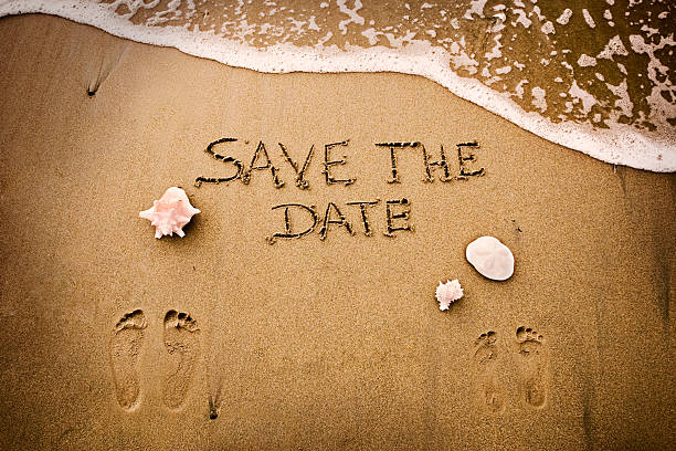 Save the date Beach with foot prints and Save The Date drawn in the sand. save the date for wedding stock pictures, royalty-free photos & images