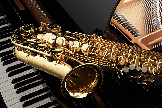Saxophone Alt saxophone on grand piano wind instrument stock pictures, royalty-free photos & images