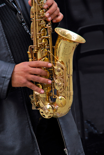 Detail of a street musician playing an old saxophone