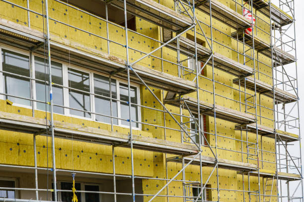 scaffolding arround the house to install thermal insulation of the apartment building facade scaffolding arround the house to install thermal insulation of the apartment building facade, blue sky background restoring stock pictures, royalty-free photos & images