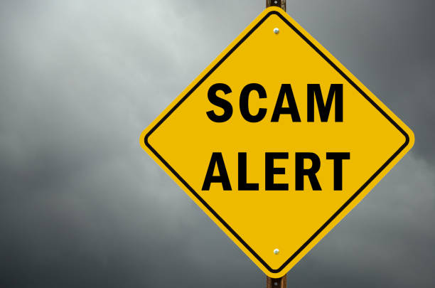 Scam alert conceptual traffic sign and stormy sky stock photo