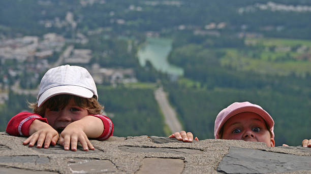 Scared Children Hanging From A Ledge stock photo