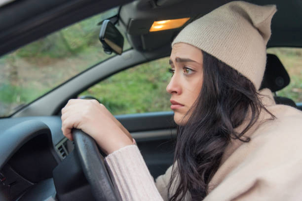 Scared woman driver in car. Inexperienced anxious motorist stock photo