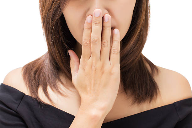 Scared young woman with her hand on her mouth Scared young woman with her hand on her mouth bad breath stock pictures, royalty-free photos & images