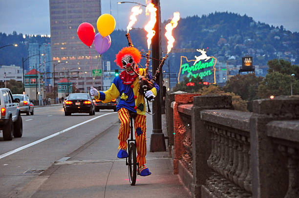 Scary Clown Riding a Unicycle Playing Flaming Bagpipes in Portland stock photo