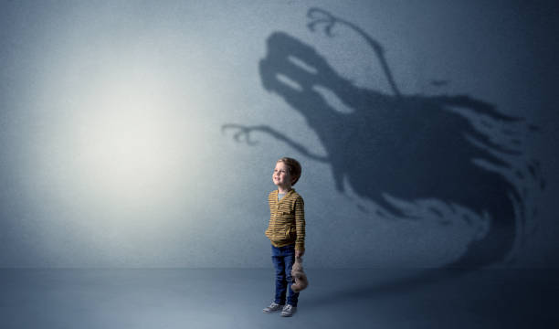 Scary ghost shadow behind kid Scary ghost shadow in a dark empty room with a cute blond child ghost boy stock pictures, royalty-free photos & images