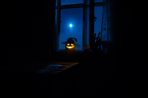 Scary Halloween Pumpkin In The Mystical House Window At Night Or Halloween Pumpkin In Night On Room With Blue Window Symbol Of Halloween In Window Stock Photo - Download Image Now - iStock
