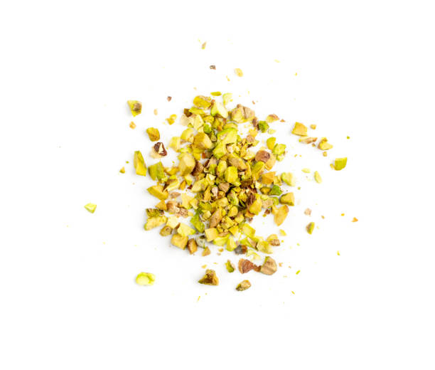 Scattered Pistachio Nut Pieces, Break Chopped Pistachios Scattered pistachio nut pieces isolated. Break chopped pistachios pile, fried baked diced pistache on white background top view pistachio stock pictures, royalty-free photos & images