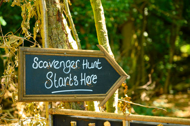 Scavenger hunt this way signpost in lush forest woodland Scavnger hunt game signage scavenging stock pictures, royalty-free photos & images