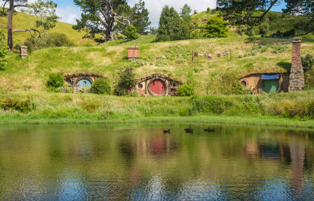 Scenery view of Hobbit holes at the waterfront in Hobbiton movie set in Matamata, New Zealand. stock photo
