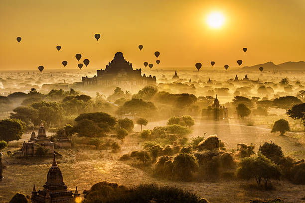 Scenic sunrise above Bagan in Myanmar Scenic sunrise with many hot air balloons above Bagan in Myanmar. Bagan is an ancient city with thousands of historic buddhist temples and stupas. synagogue stock pictures, royalty-free photos & images