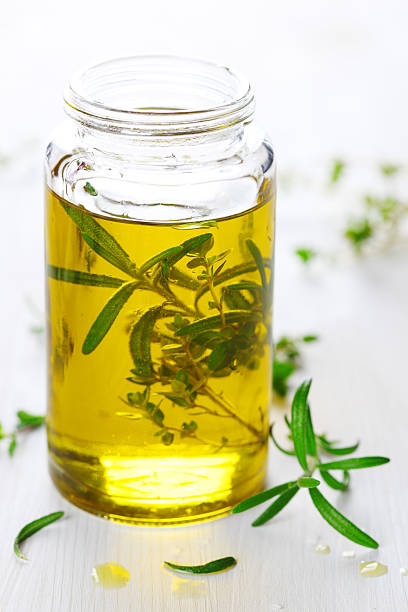 Scented oil with rosemary and fresh herbs stock photo