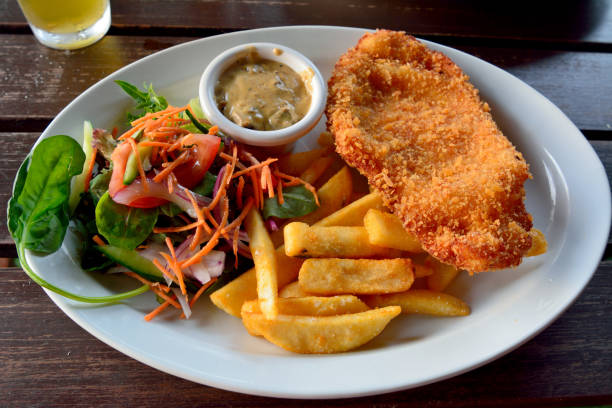 Schnitzel with salad, mushroom sauce and french fries stock photo