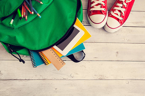 school backpack on wooden background - school material imagens e fotografias de stock