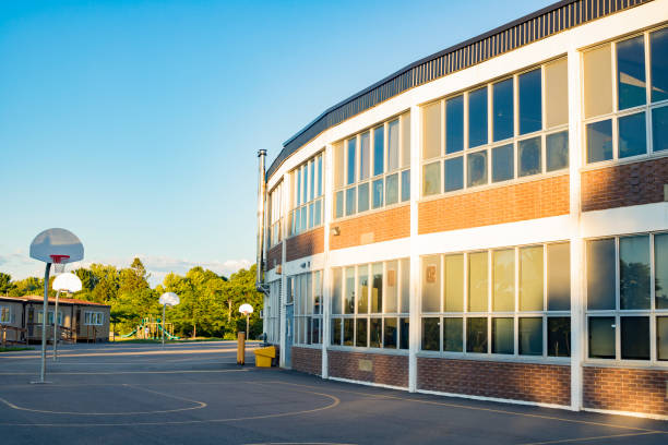 School building with schoolyard School building and school yard with basketball court school exteriors stock pictures, royalty-free photos & images