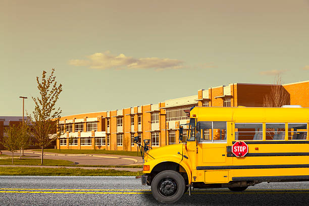 School bus in front of a school School Bus school exteriors stock pictures, royalty-free photos & images