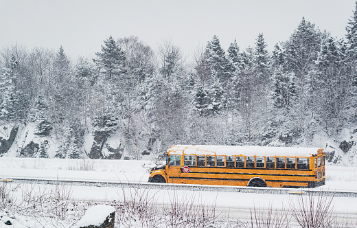 A school bus driver navigates a highway during heavy snow.