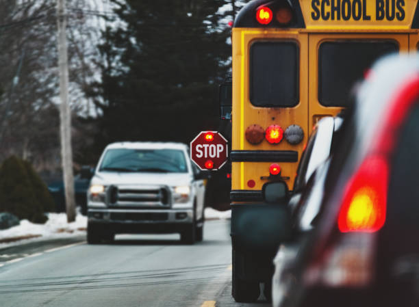 School Bus A school bus stops to drop off children. school bus driver stock pictures, royalty-free photos & images