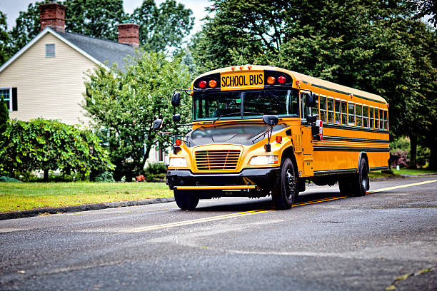 School bus Yellow school bus driving along street school bus driver stock pictures, royalty-free photos & images
