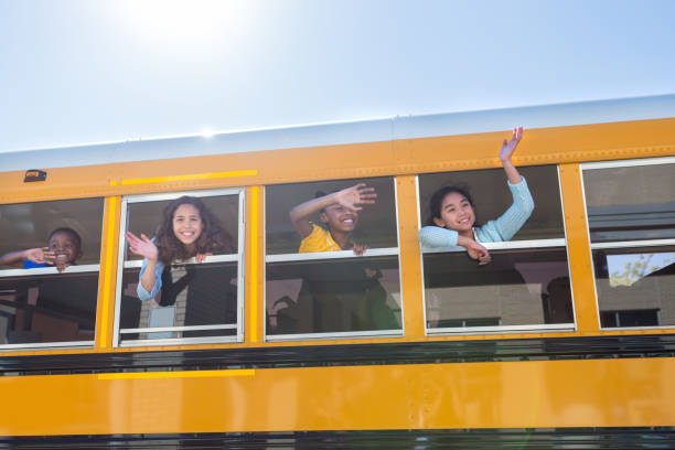 School children wave from school bus Diverse school children wave goodbye from school bus. They are excited for the first day of school. wave goodbye asian stock pictures, royalty-free photos & images