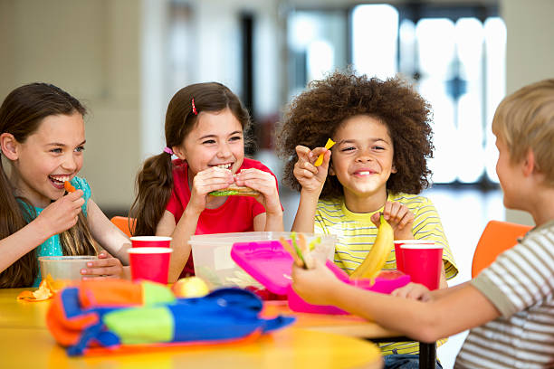 School Dinners Group of children having packed lunches cafeteria stock pictures, royalty-free photos & images