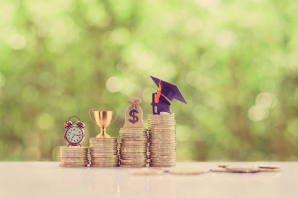 School funding, saving for higher education concept : Black graduation cap, campus diploma, US dollar bag, trophy cup of success or winner reward, a clock on rising coins, depicts passage of success School funding, saving for higher education concept : Black graduation cap, campus diploma, US dollar bag, trophy cup of success or winner reward, a clock on rising coins, depicts passage of success student loan  stock pictures, royalty-free photos & images